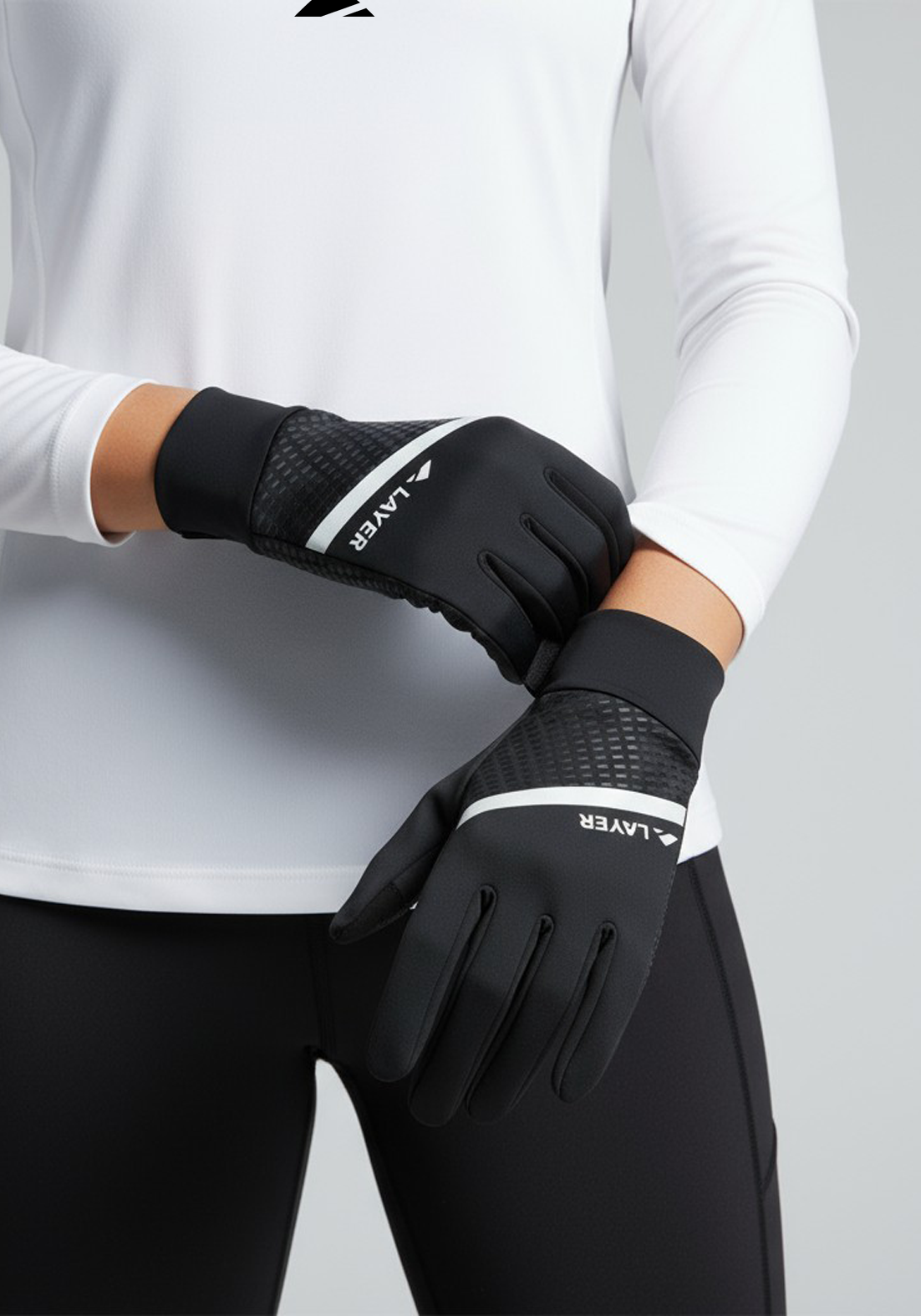 Runner wearing the Layer COLDLYR Run Gloves paired with black leggings and a white long-sleeve top, showing the reflective detailing in use.