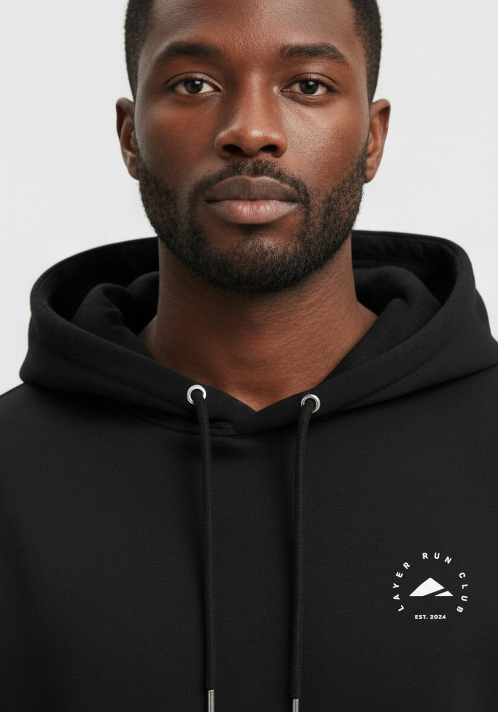 Close up of Layer Run Club black hoodie chest logo and drawstring detail