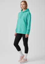 Female model wearing the Layer Run Club hoodie in green, front view showing chest logo and relaxed fit.