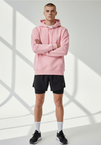 Male athlete wearing the Layer Run Club hoodie in pink, front view showing chest logo and relaxed unisex fit.
