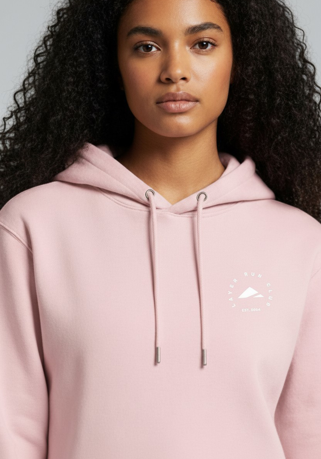 Close up of the Layer Run Club logo on pink hoodie, showing clean print and premium fabric finish.