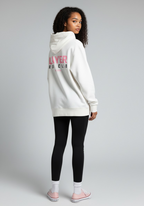 Female athlete wearing the Layer Run Club hoodie in white, back view showing Layer Run Club print, styled with leggings.