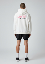 Male athlete wearing the white Layer Run Club hoodie, back view with bold Layer Run Club branding.