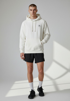 Male runner wearing the Layer Run Club hoodie in white, front view showing chest logo and relaxed unisex fit.