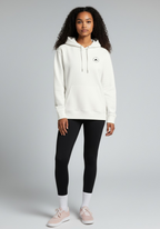 Female athlete wearing the white Layer Run Club hoodie, front view styled for everyday training and recovery.