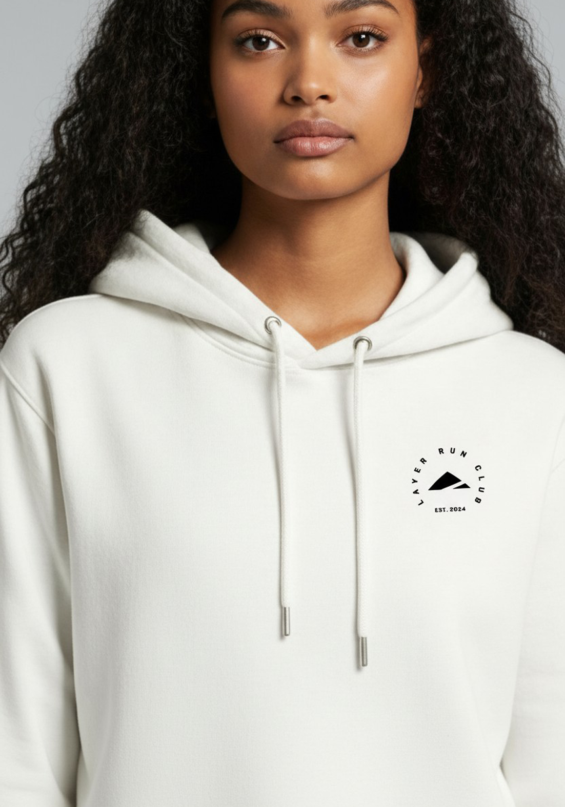 Close up of the Layer Run Club logo on white hoodie, showing clean print and premium fabric texture.