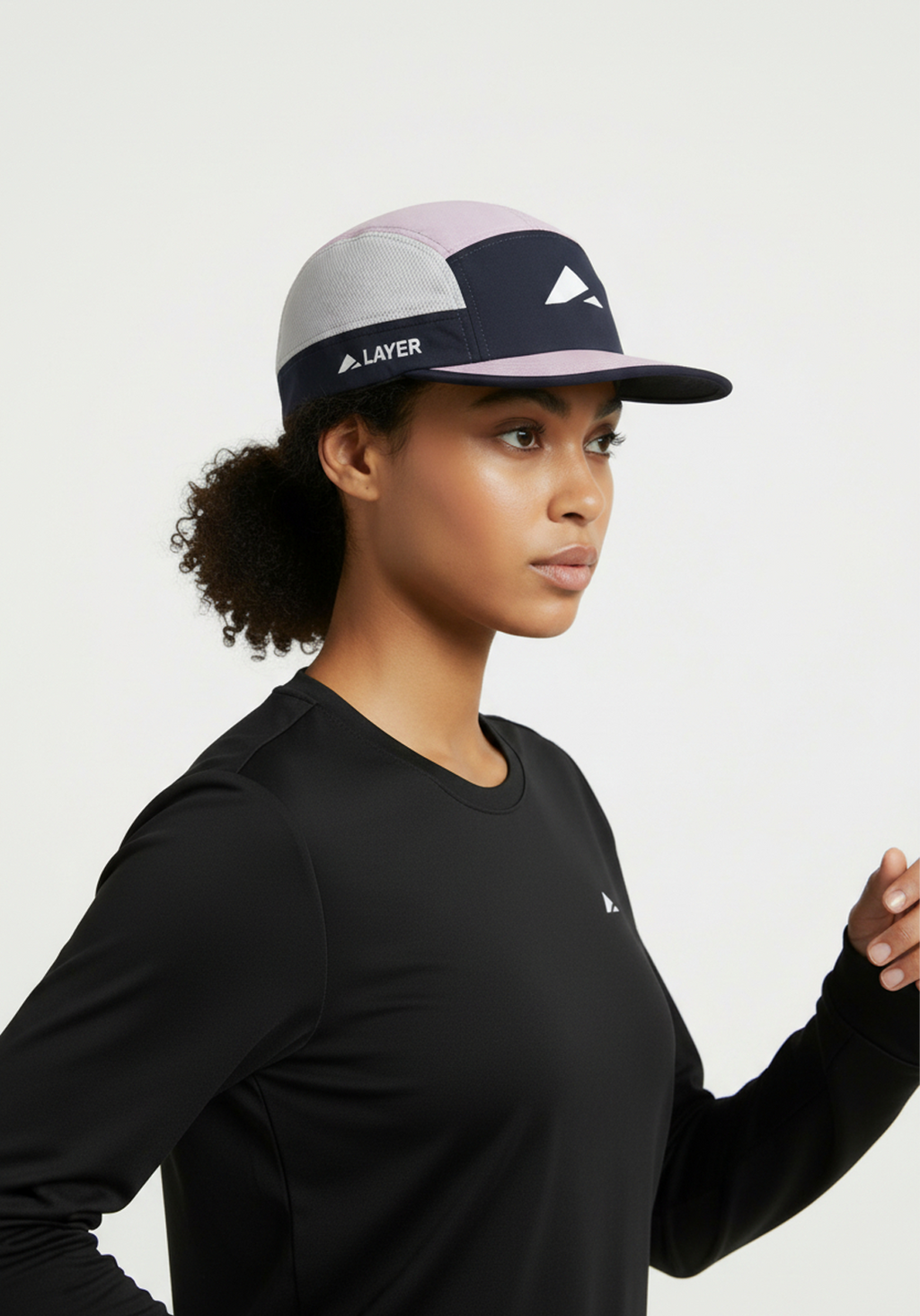 Woman wearing the Layer Running Cap in navy and lilac shown from the side while running