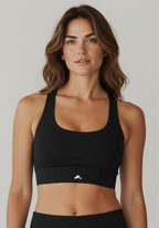 Close up front view of the Layer Performance Bra in black with scoop neckline and firm support