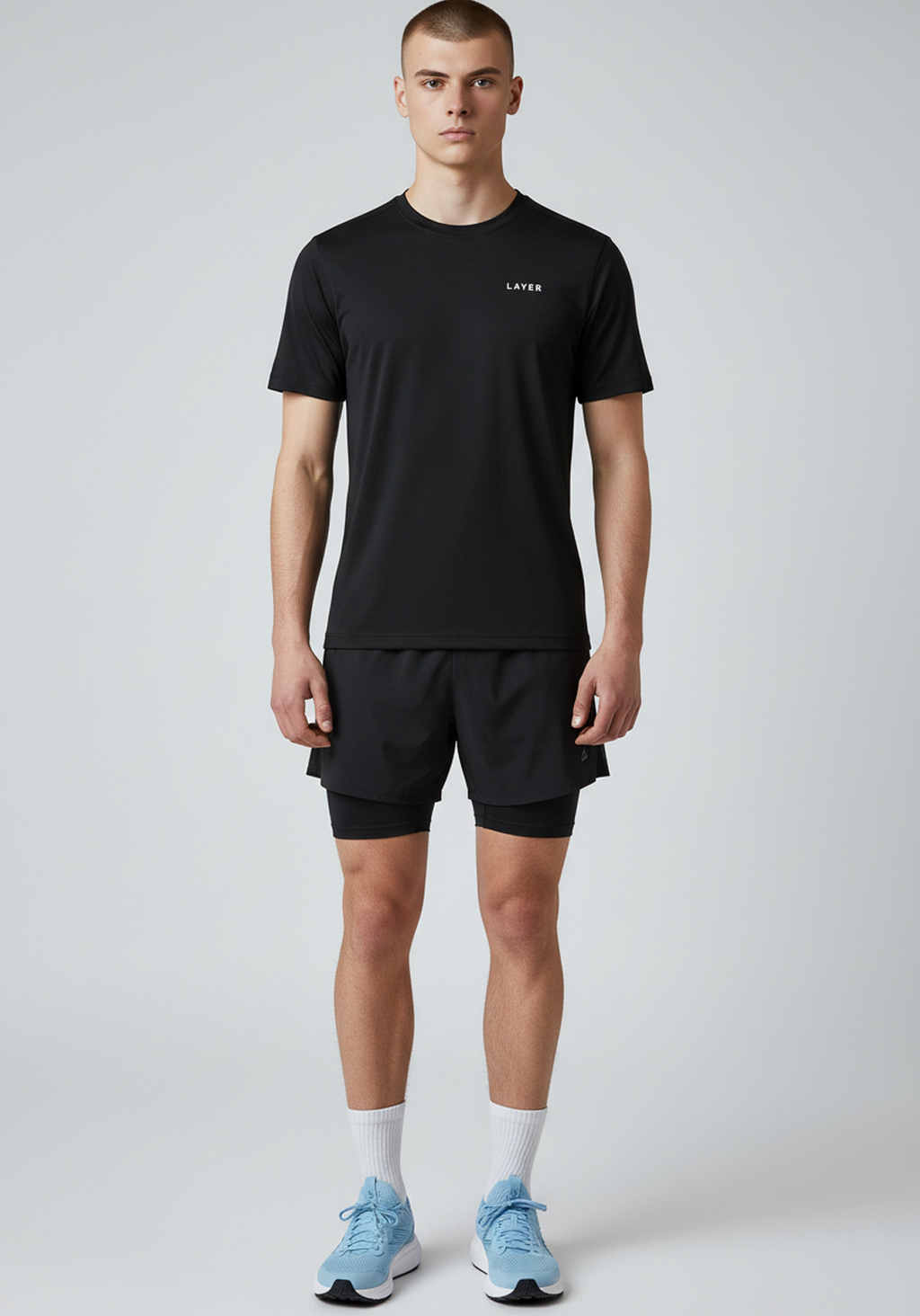 Full body front view of men’s black Layer FTR graphic running tee worn with running shorts