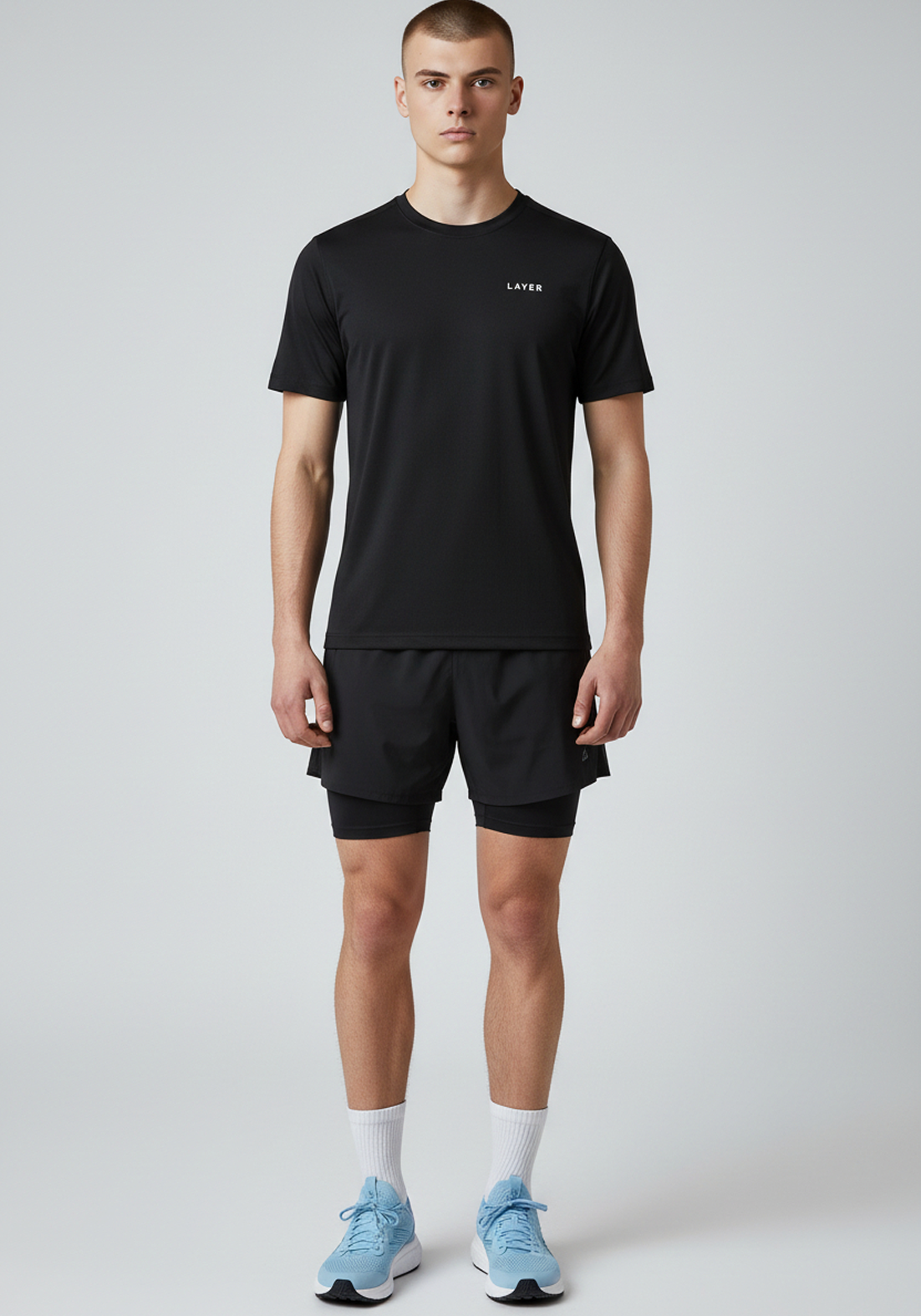 Full body front view of men’s black Layer FTR graphic running tee worn with running shorts