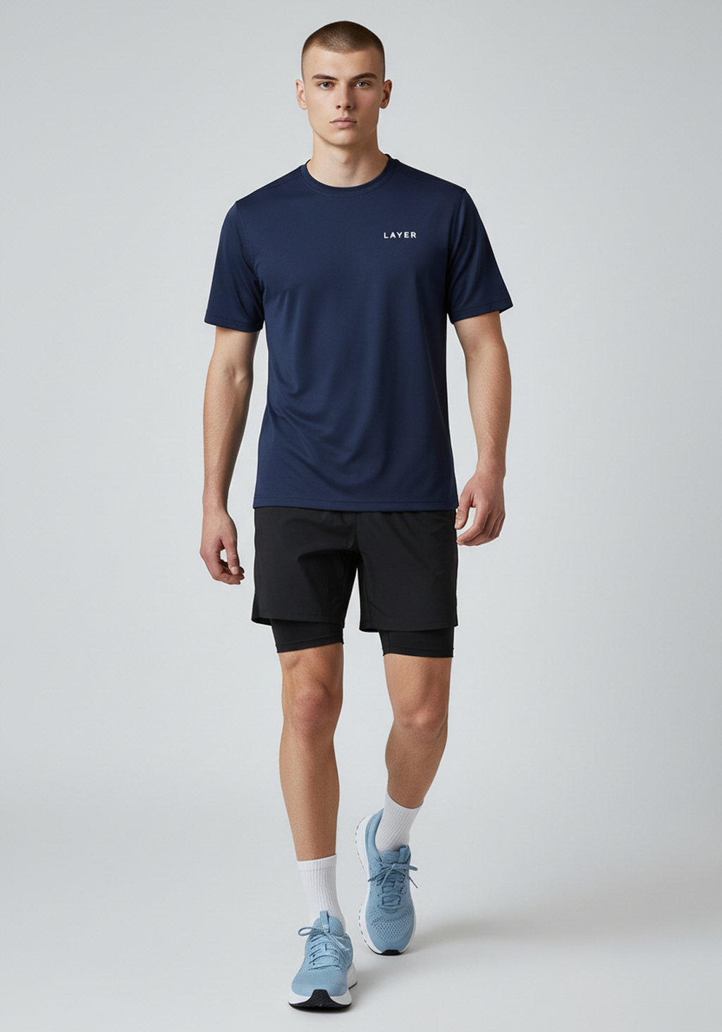 Full body front view of men’s navy Layer FTR graphic running tee worn with running shorts