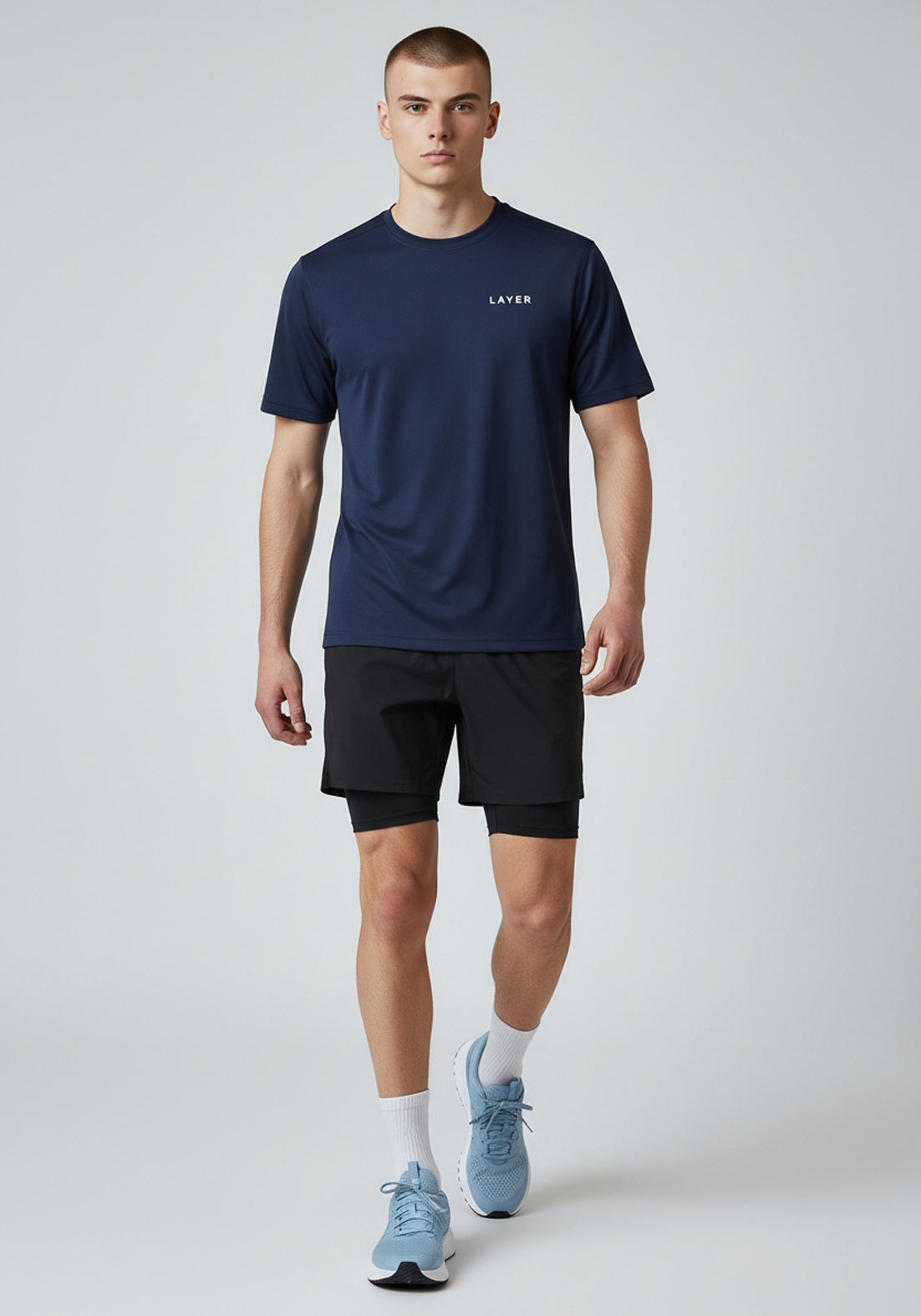 Full body front view of men’s navy Layer FTR graphic running tee worn with running shorts
