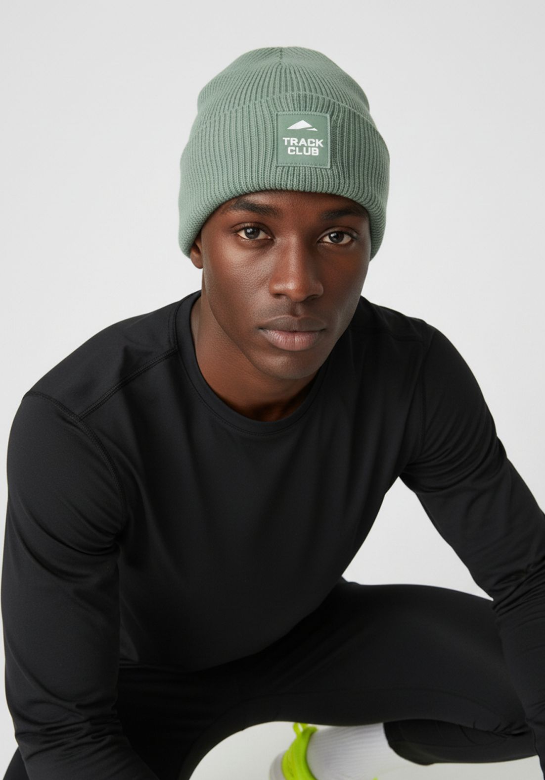 Alpine green Layer Track Club beanie worn with Layer performance training kit