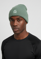 Close up of alpine green Layer Track Club beanie fabric and patch detail