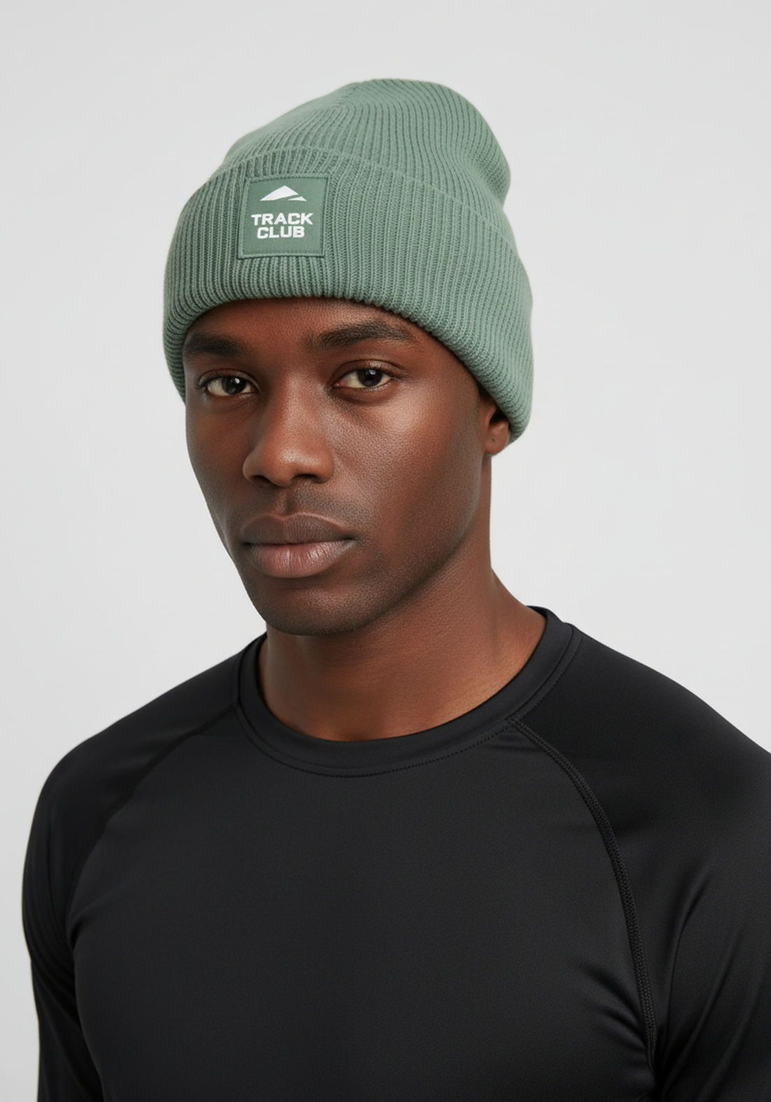 Close up of alpine green Layer Track Club beanie fabric and patch detail