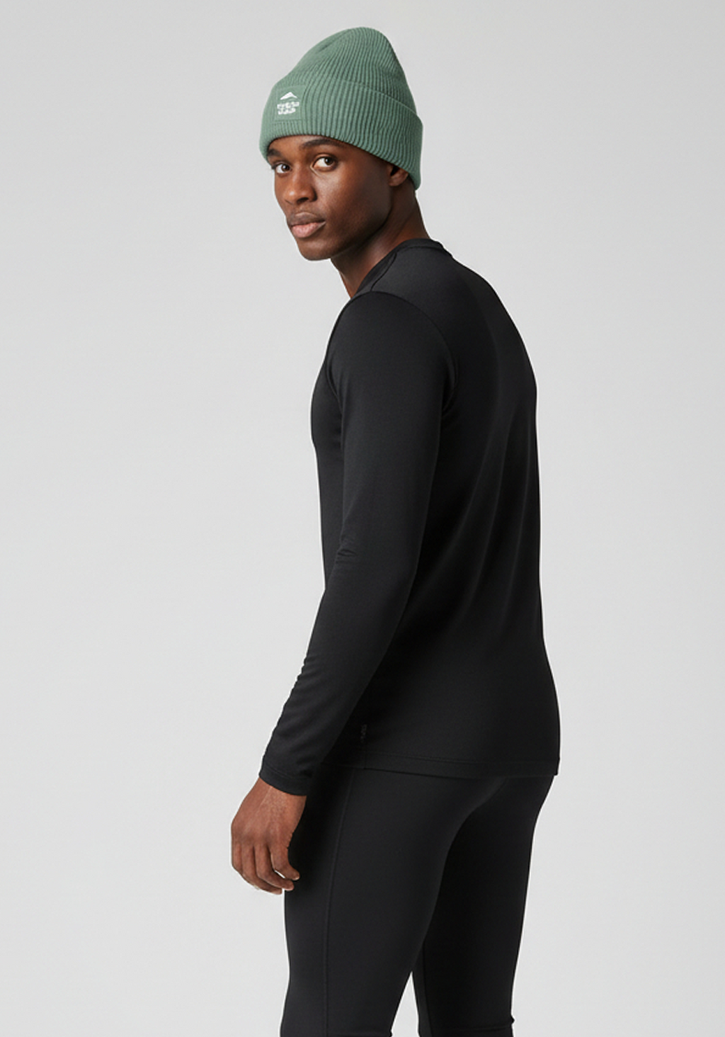 Model wearing alpine green Layer Track Club beanie, side profile