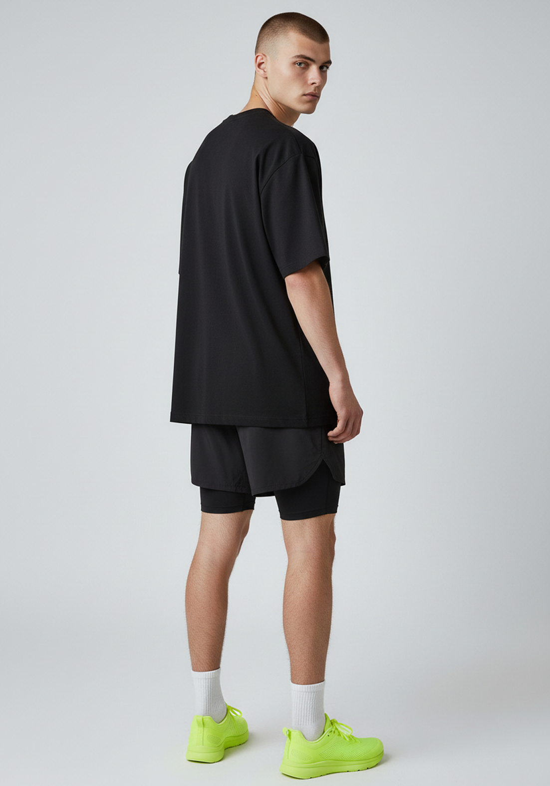 Side profile of the black Layer Track Club Tee showing straight hem and loose fit.