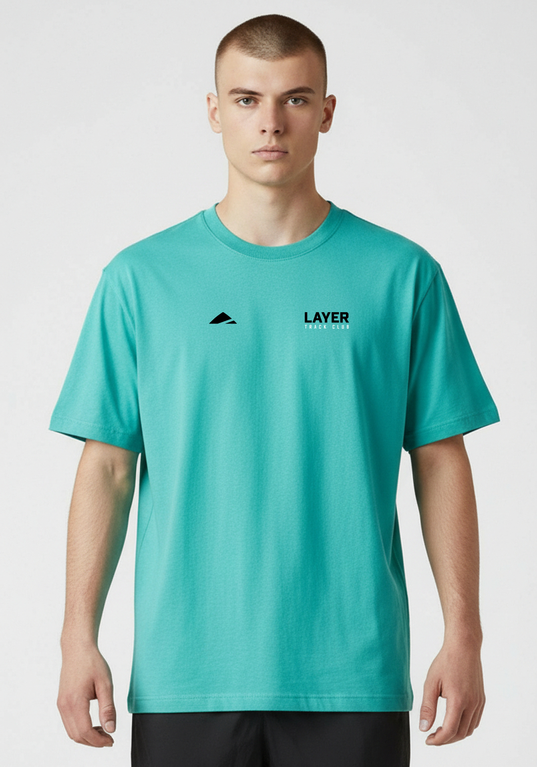 Close up of the teal Layer Track Club Tee showing Layer logo and Track Club text.