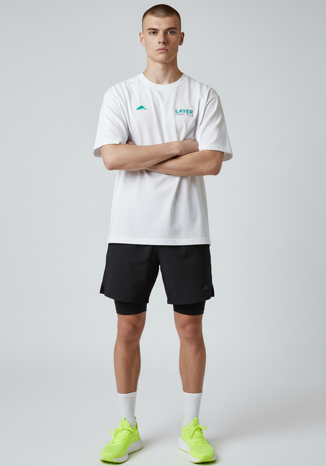 Model wearing white Layer Track Club tee with arms crossed front view