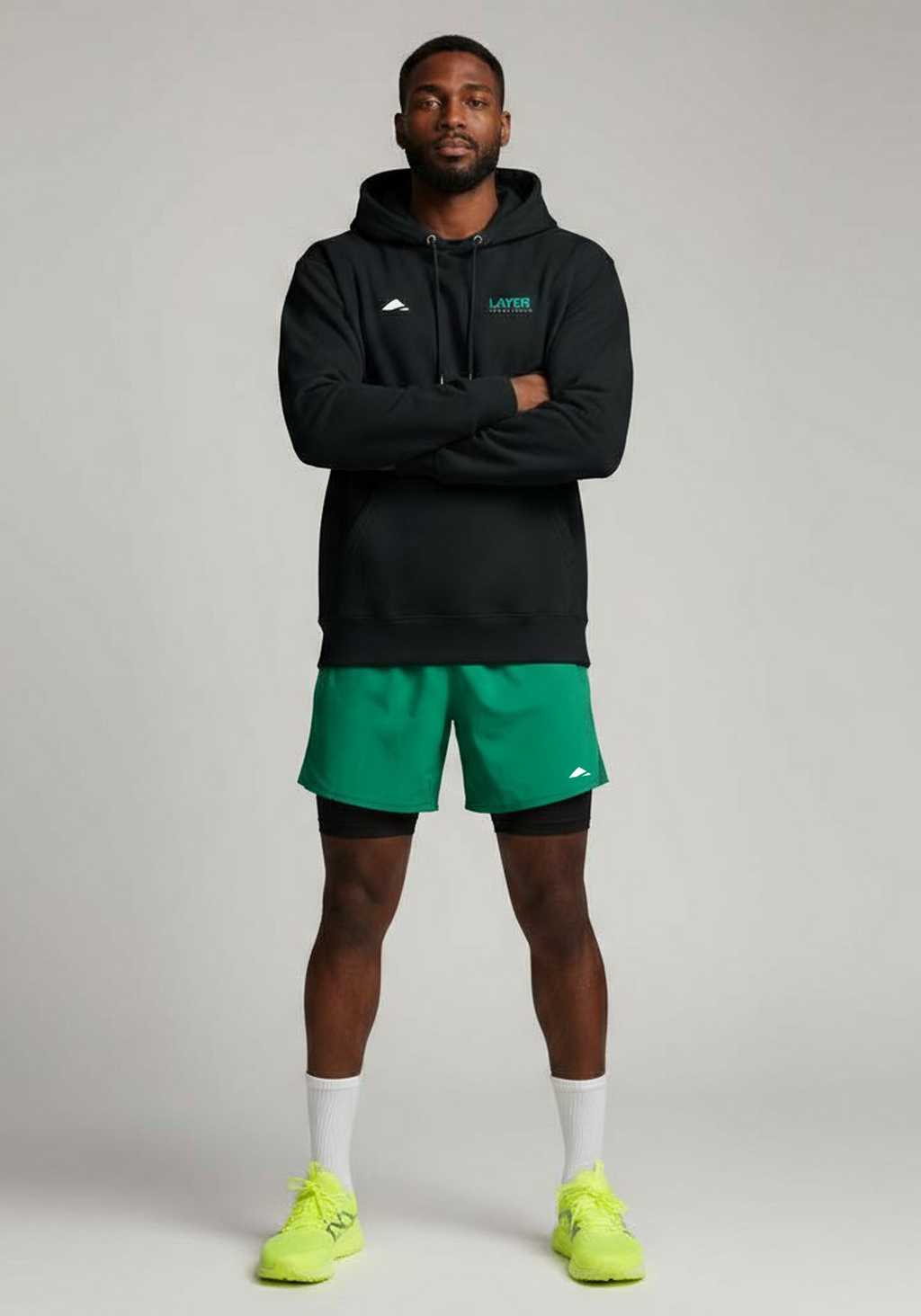 Layer Men’s Track Club Hoodie in black – on-model front view with arms crossed showing structured fit and clean construction