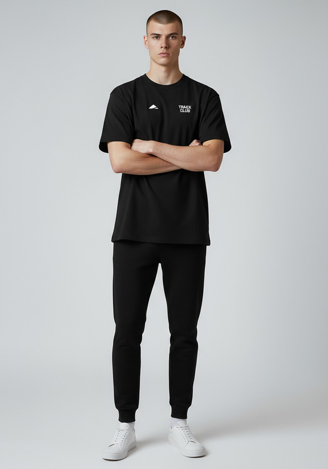 Layer Track Club Tee in black – full-body front view on model showing minimalist chest print and athletic fit