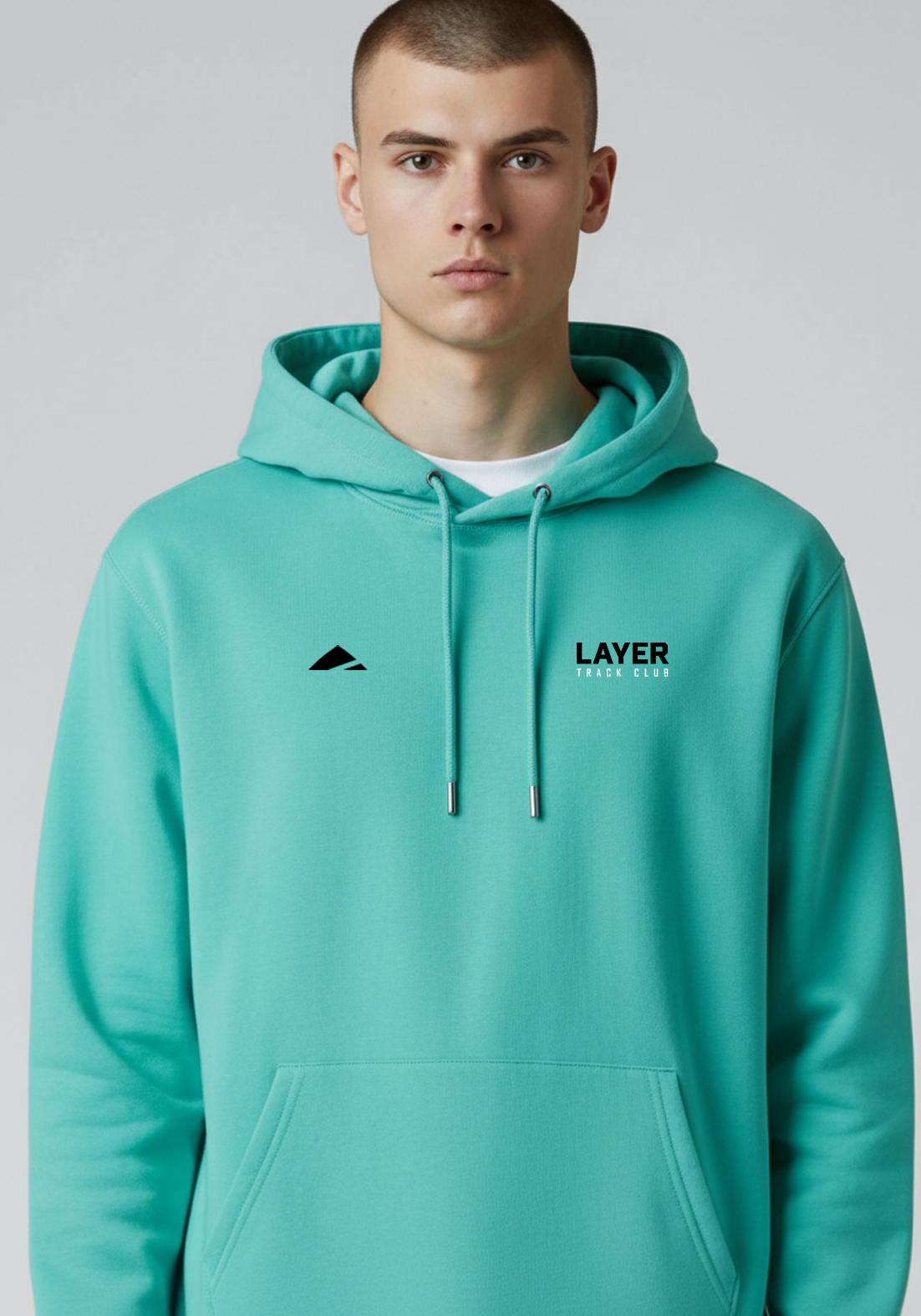 Front view of model wearing the Layer Track Club Hoodie in teal showing relaxed fit and Track Club branding