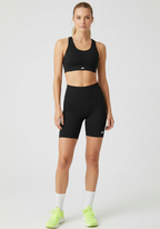 Full front view of women wearing black Layer Training Legging Shorts styled with matching sports bra.
