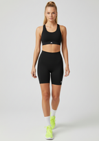 Walking front view of black Layer Training Legging Shorts showing secure fit and mid-thigh length.