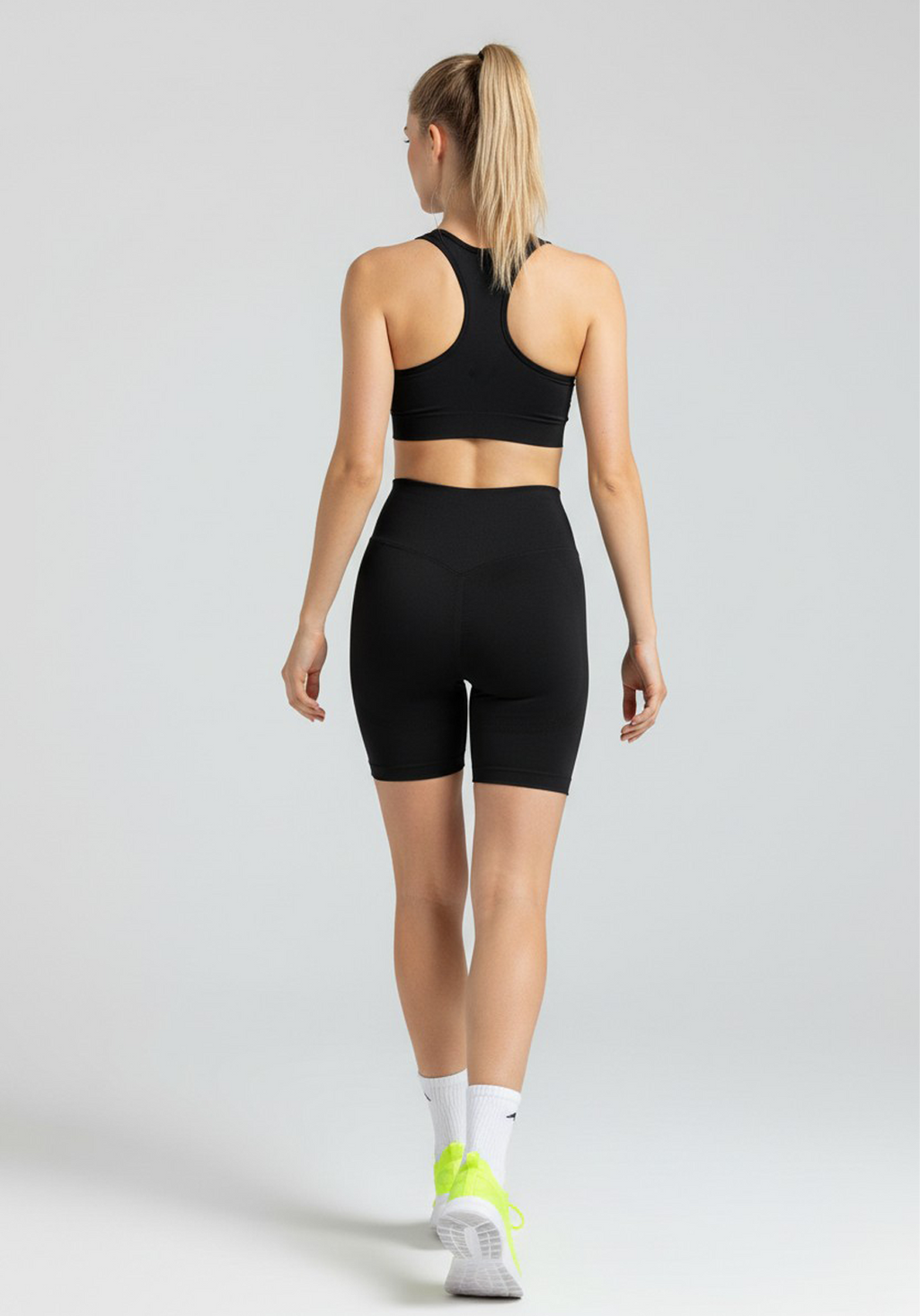 Back view of women wearing black Layer Training Legging Shorts with high-rise waistband and supportive fit.