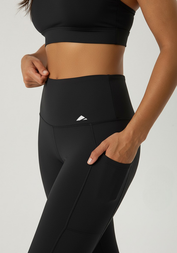 Close-up of black Vento Hybrid Performance Leggings showing high-waisted waistband, side pocket, and smooth compression fabric.