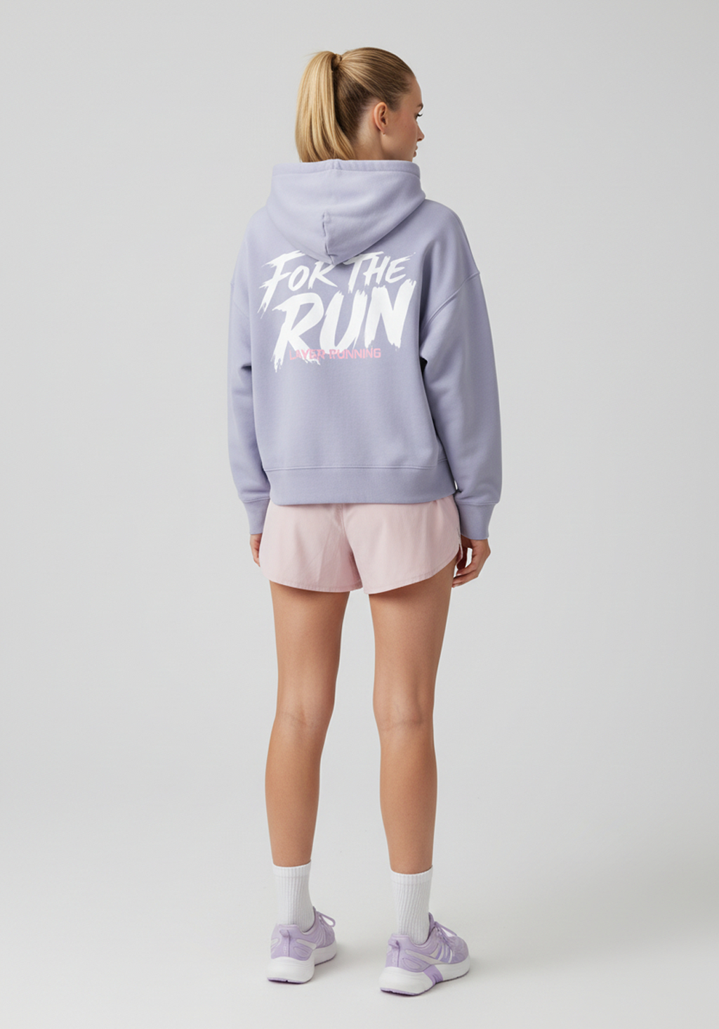 Side back view of women’s lavender Layer FTR Graphic Hoodie showing hood and relaxed silhouette