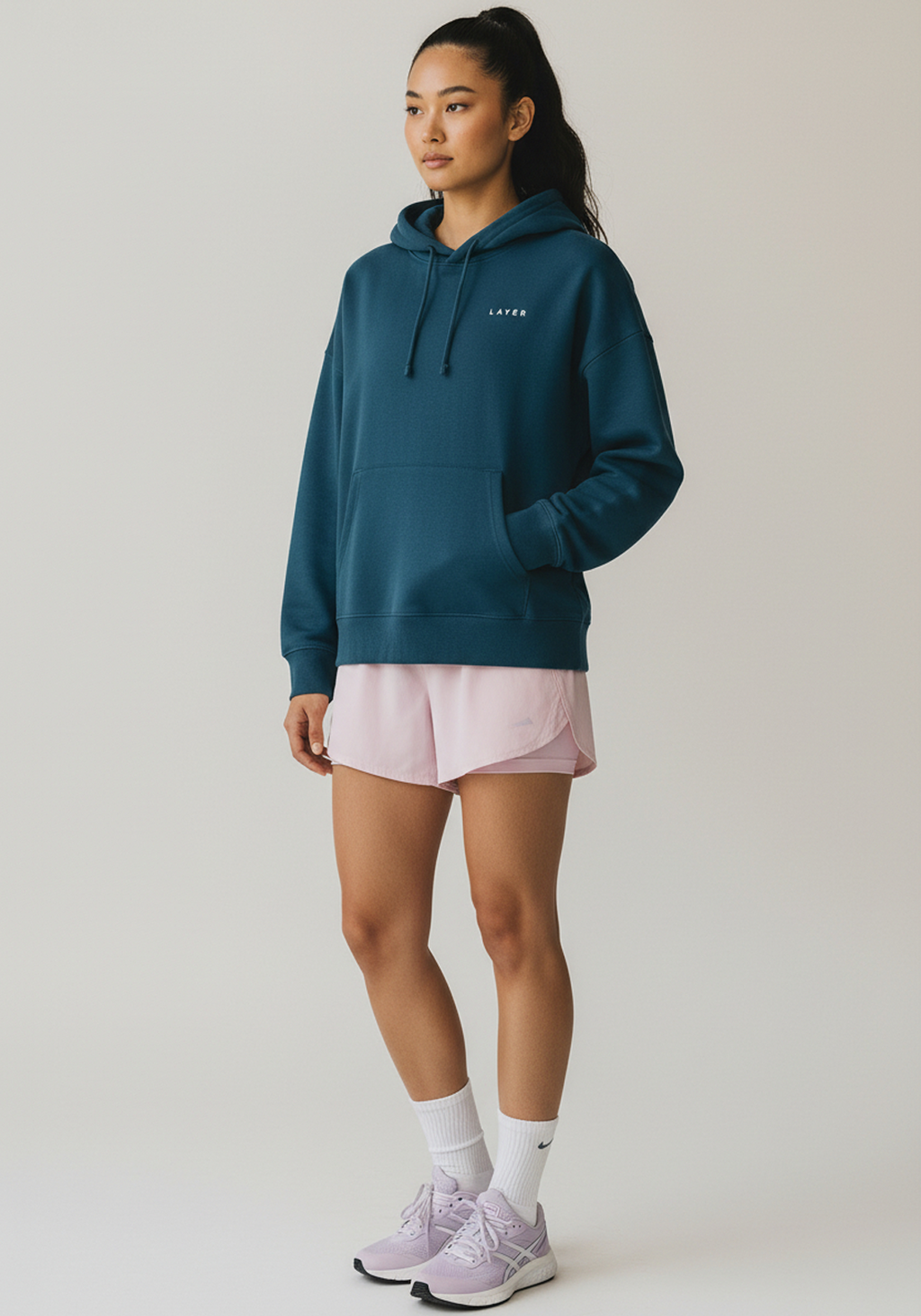 Women wearing lavender Layer FTR hoodie, front angled view with kangaroo pocket