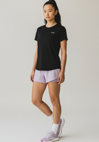 Front three-quarter view of black Women’s FTR Graphic Running Tee with subtle Layer chest logo.