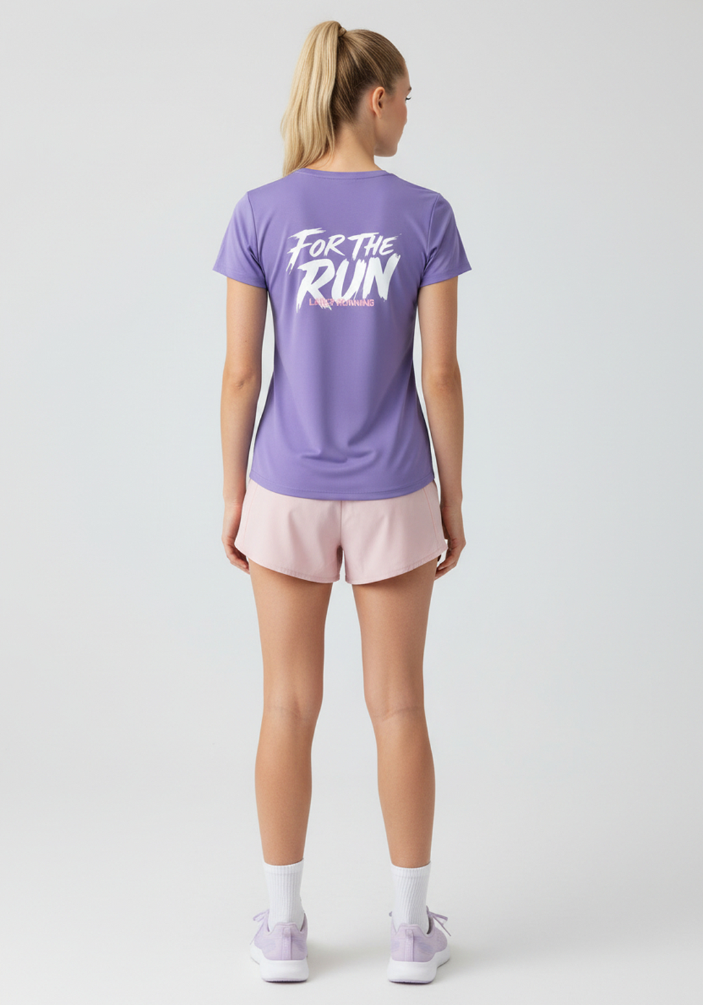 Angled rear view of lavender Layer FTR Graphic Run Tee showing relaxed fit and For The Run back graphic