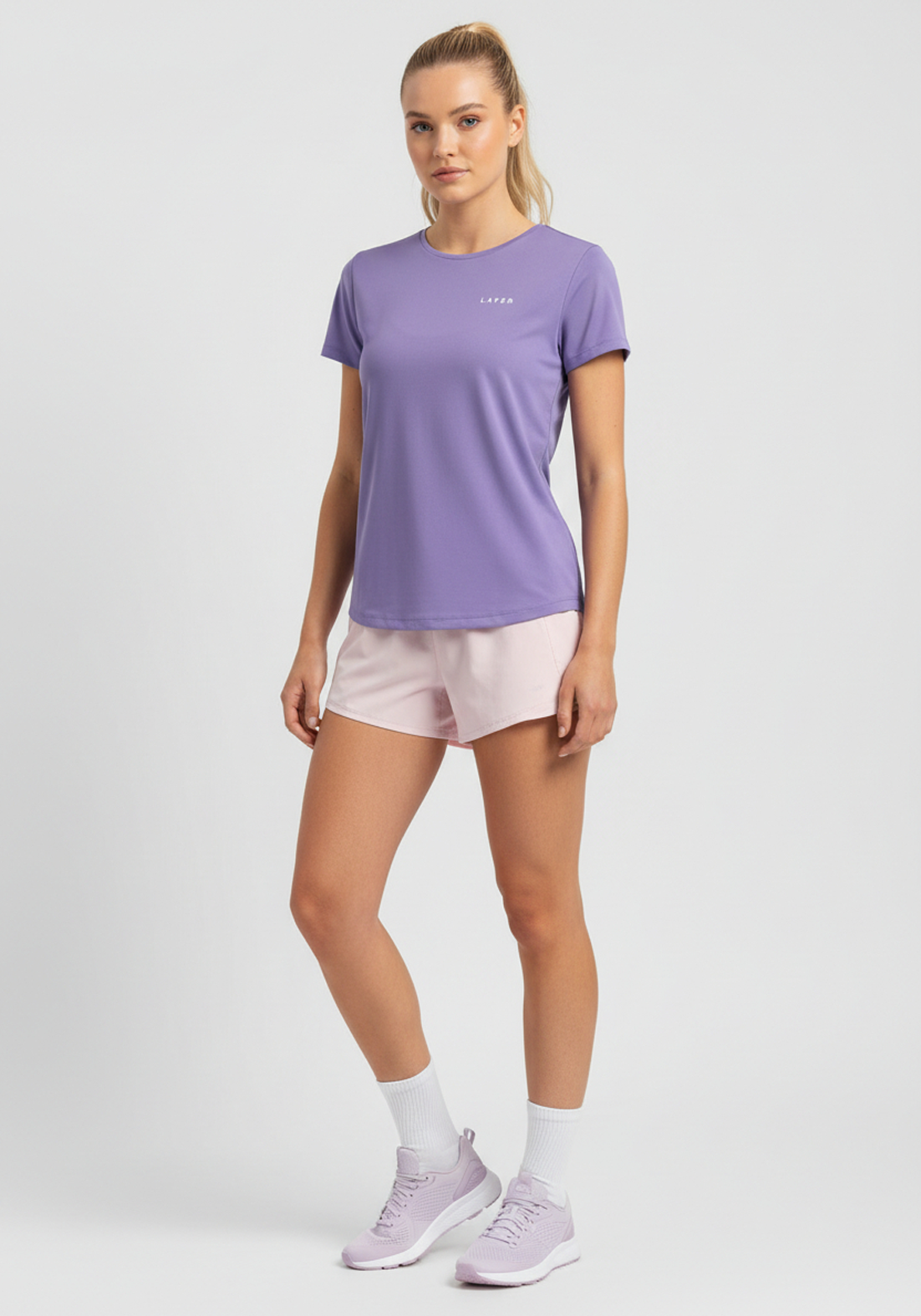 Women wearing lavender Layer FTR Graphic Run Tee with short sleeves and relaxed athletic fit, paired with light pink running shorts