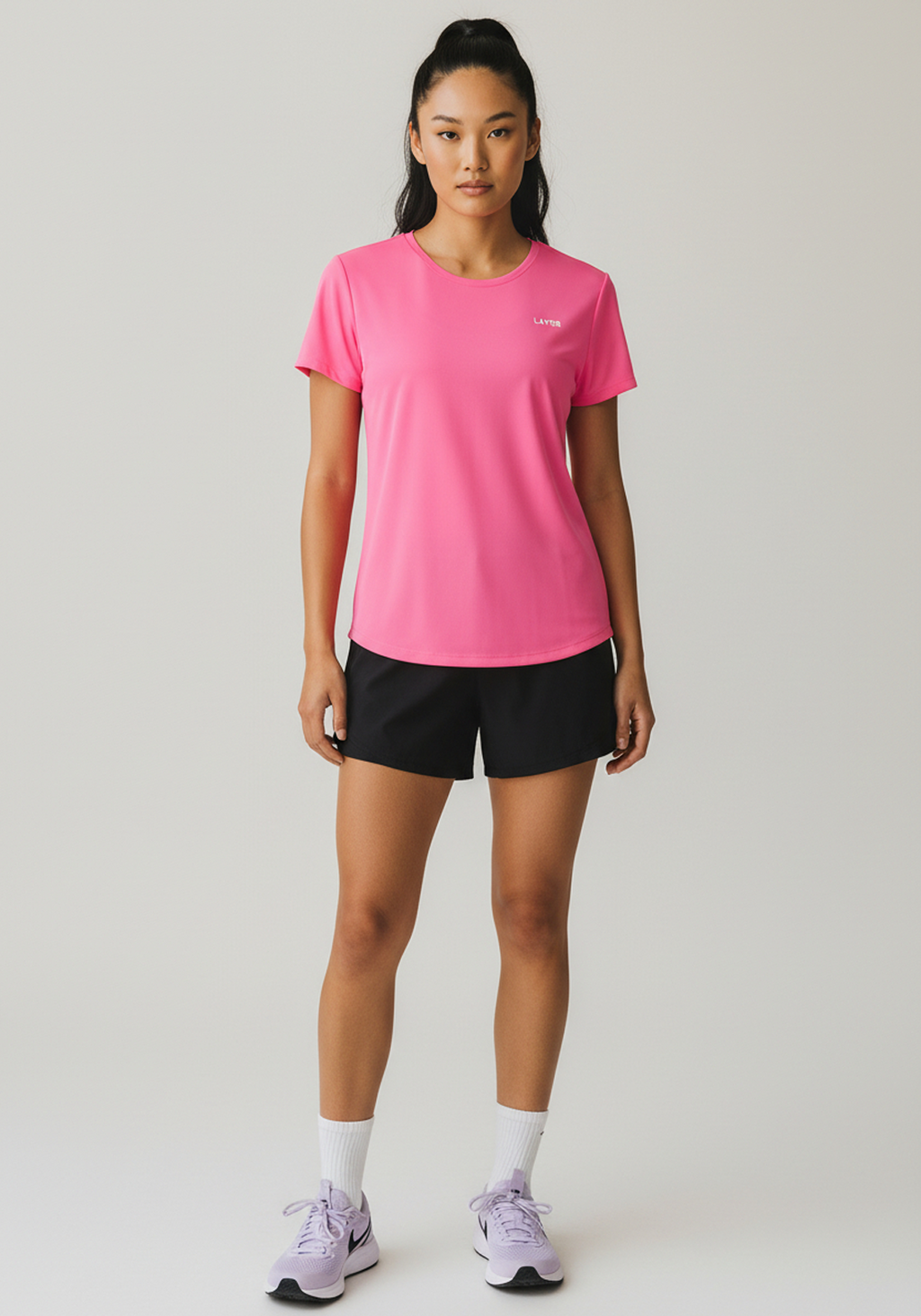 Front view of pink Layer Women’s FTR Graphic Running Tee showing relaxed fit and minimal chest logo.