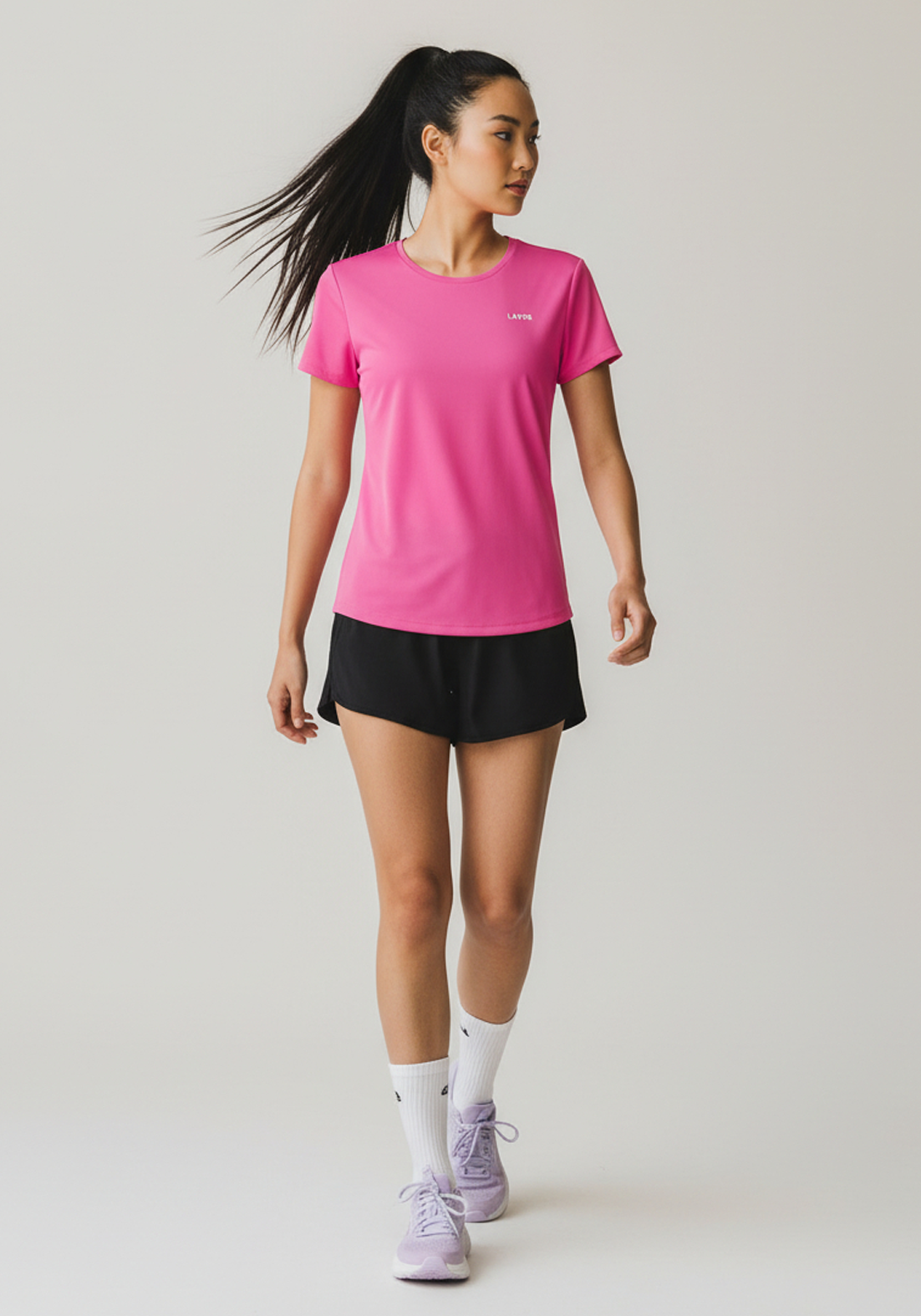 Side angle of woman in pink Layer Women’s FTR Graphic Running Tee during movement, showing lightweight athletic fit.